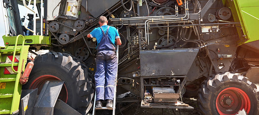 combine-machine-service-mechanic-repairing-motor-outdoors.jpg